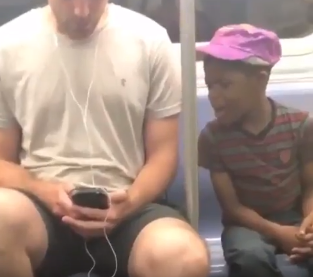 Man gives his phone to a boy who was staring at it