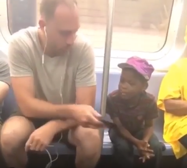 Man gives his phone to a boy who was staring at it