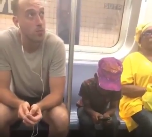 Man on subway gives his phone to a boy who was staring at it