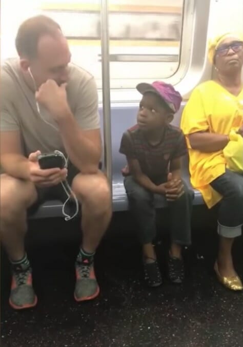 Man gives his phone to a boy who was staring at it