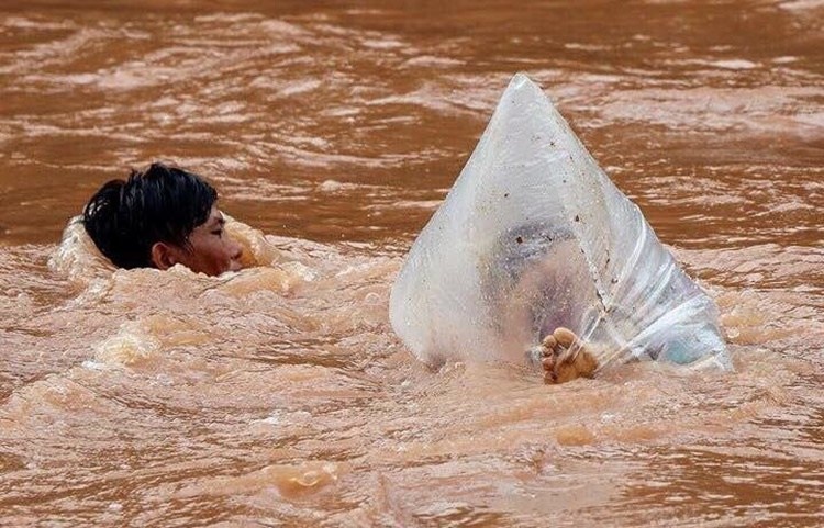 Man Transporting Students In Plastic Bags Through Muddy River To Get Them School Goes Viral