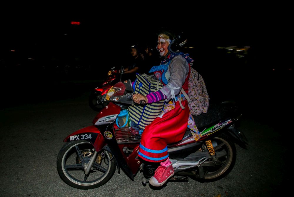 Nazirah on a bike for the stray animals dressed up as a clown on weekends